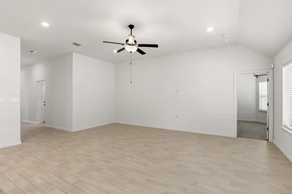 an empty room with fan and entrance