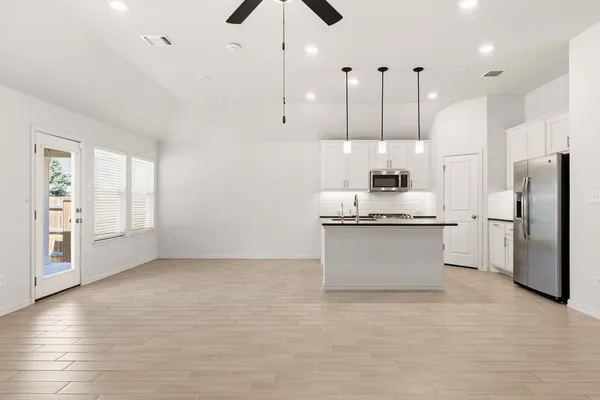 a large kitchen with stainless steel appliances kitchen island a large counter space a refrigerator and cabinets