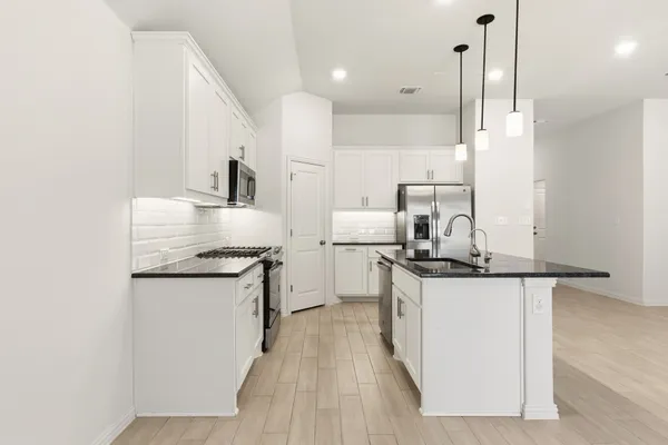 a kitchen with stainless steel appliances granite countertop a sink stove and refrigerator