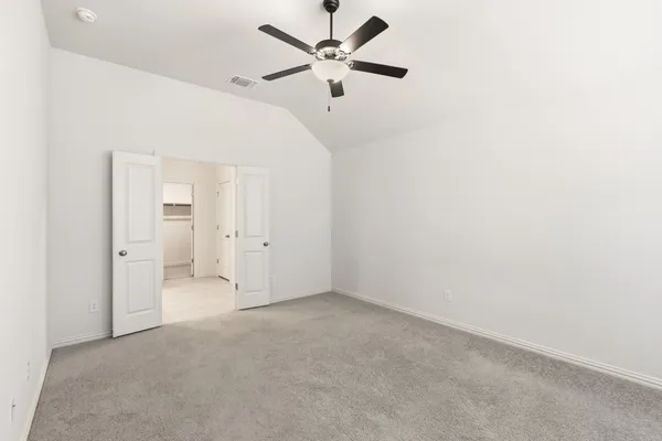 an empty room with chandelier fan and ceiling fan