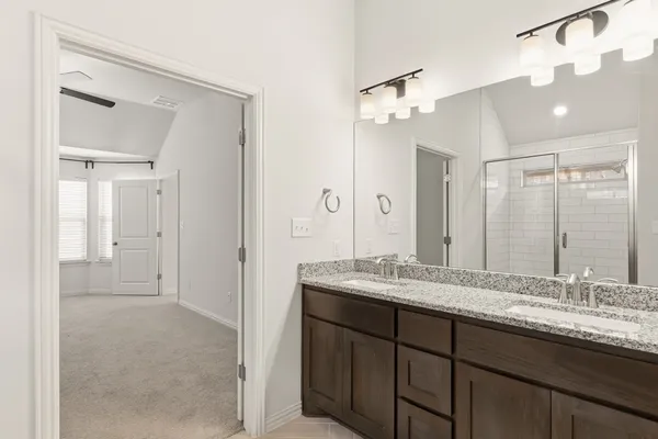 a bathroom with a granite countertop sink a mirror and a shower