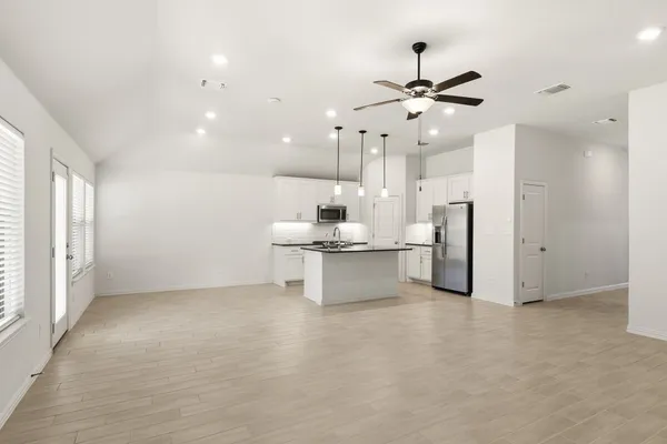 a living room with kitchen island furniture and ceiling fan
