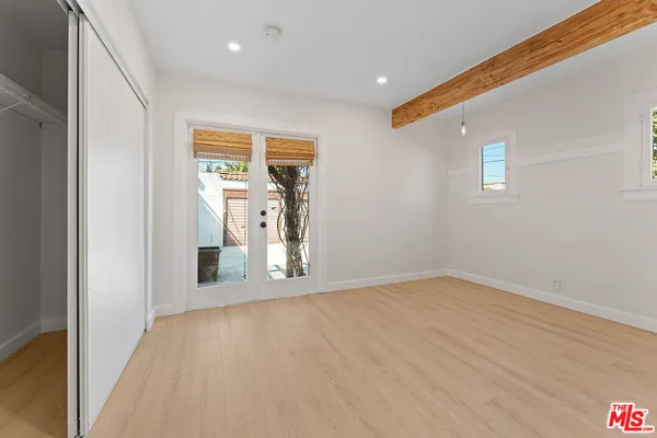 a view of a hallway with wooden floor and a bathroom