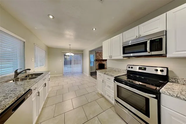 a kitchen with granite countertop a stove and cabinets