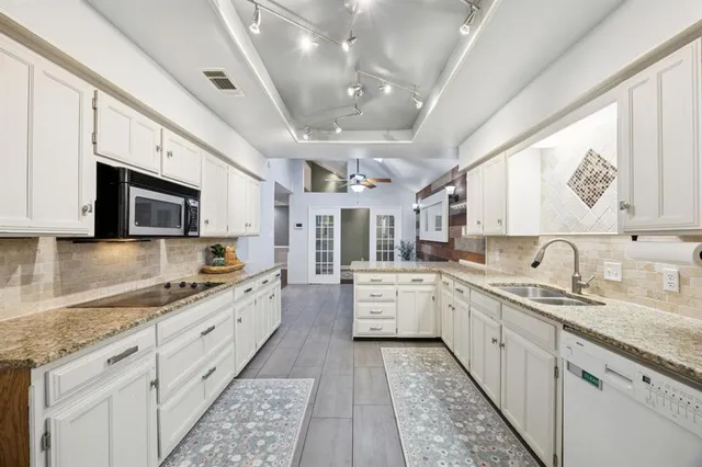 a kitchen with granite countertop cabinets stainless steel appliances and a counter space