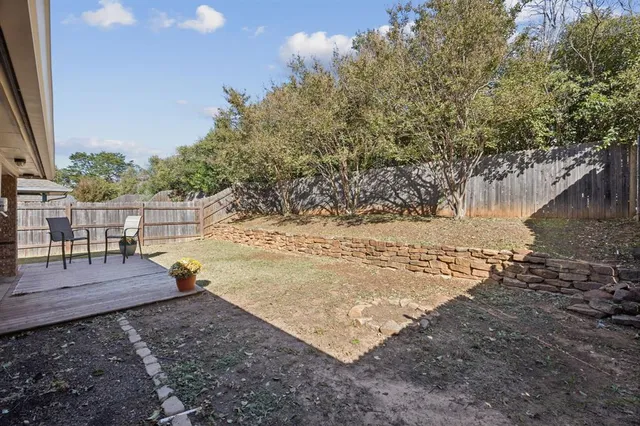 a view of a patio with table and chairs with wooden floor and fence