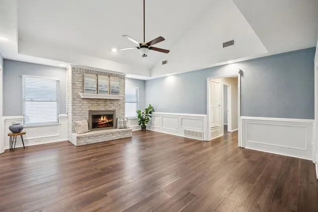 a living room with a fireplace and wooden floor