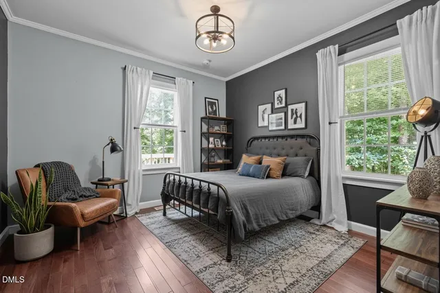 a bedroom with a large bed and wooden floor
