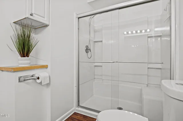 a bathroom with a shower a toilet and a sink