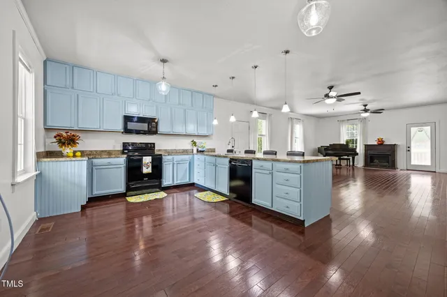 a large kitchen with cabinets and wooden floor