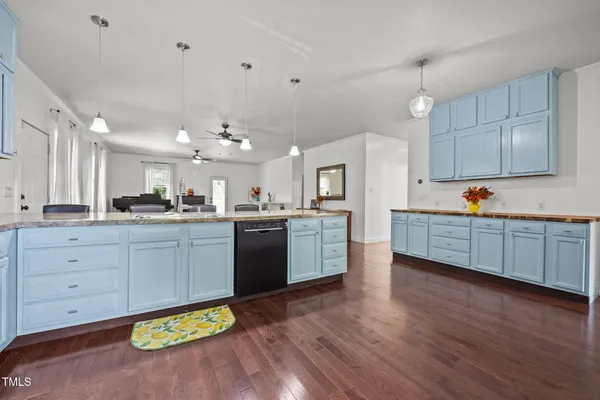 a open kitchen with lot of cabinets and wooden floor