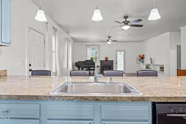 a kitchen with granite countertop a sink a counter top space and cabinets