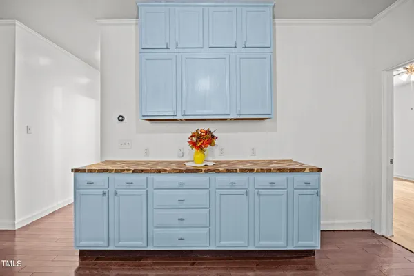 a utility room with granite countertop cabinets and wooden floor