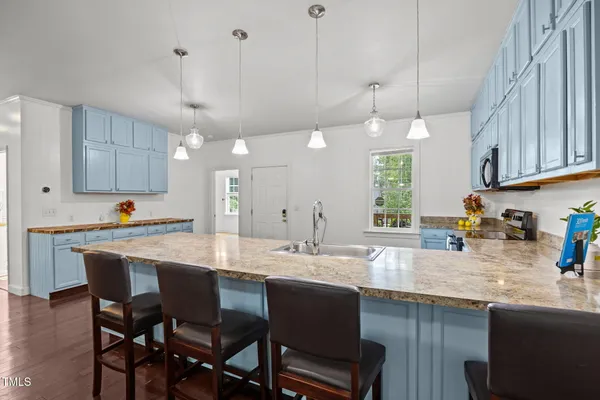 a kitchen with a dining table chairs sink and cabinets
