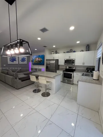 a kitchen with stainless steel appliances granite countertop a sink a stove and cabinets