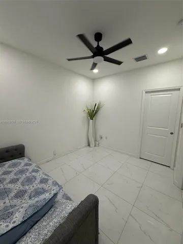 a bedroom with a bed and a ceiling fan