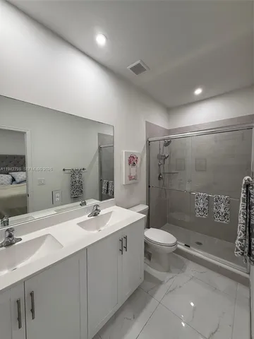 a bathroom with a shower sink and mirror