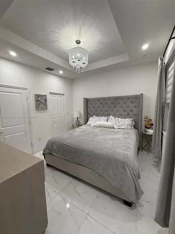 a bedroom with a bed and a chandelier
