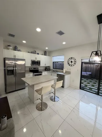 a kitchen with stainless steel appliances kitchen island granite countertop a sink and cabinets