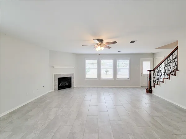 a view of an empty room with a fireplace and a window