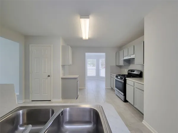 a kitchen with a sink stove and cabinets