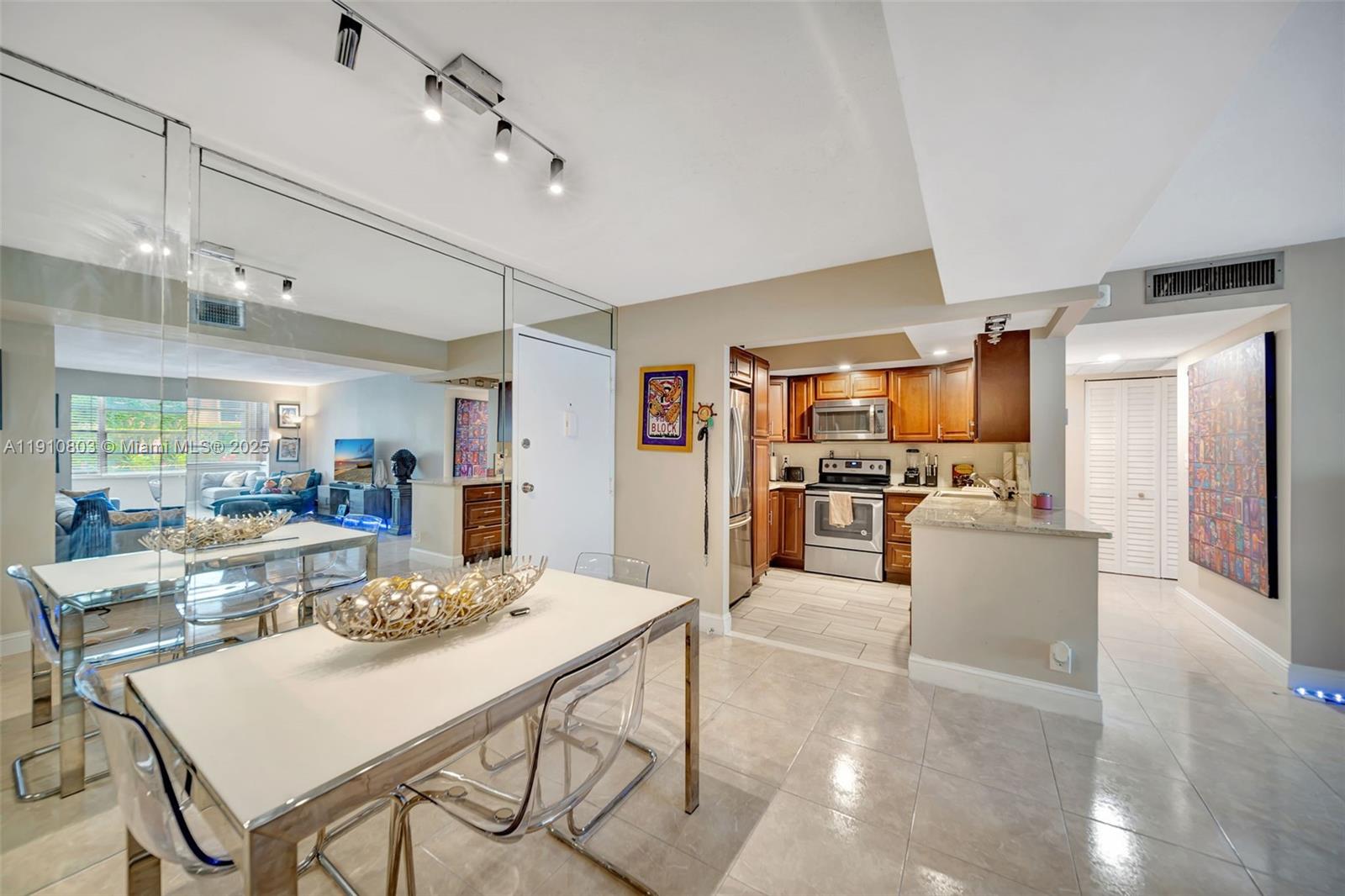 6700 Cypress Road, Unit 105 Plantation, FL 33317 - Photo 16 of 28 a kitchen with stainless steel appliances kitchen island granite countertop a refrigerator a stove top oven a sink dishwasher and white cabinets with wooden floor