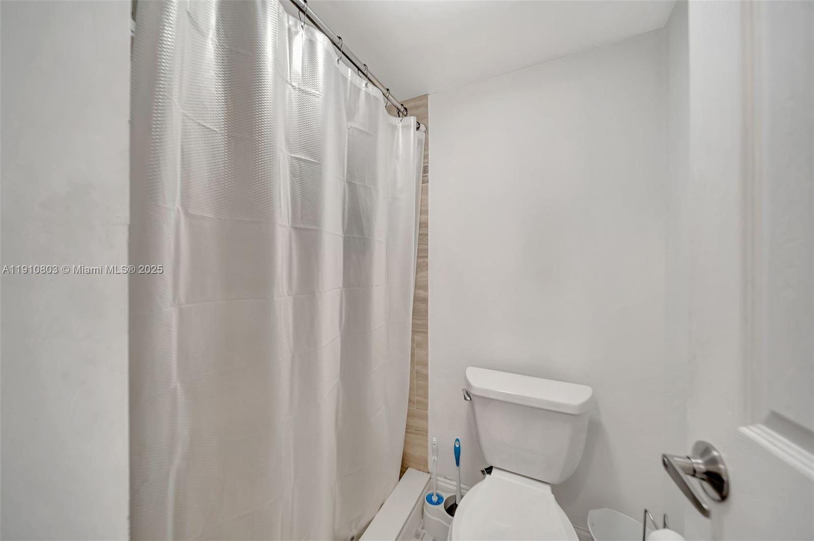 6700 Cypress Road, Unit 105 Plantation, FL 33317 - Photo 21 of 28 a white toilet sitting next to a shower curtain