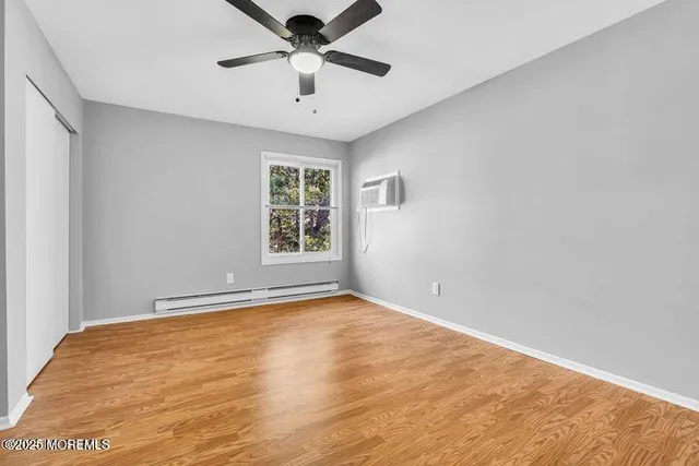 an empty room with windows and ceiling fan