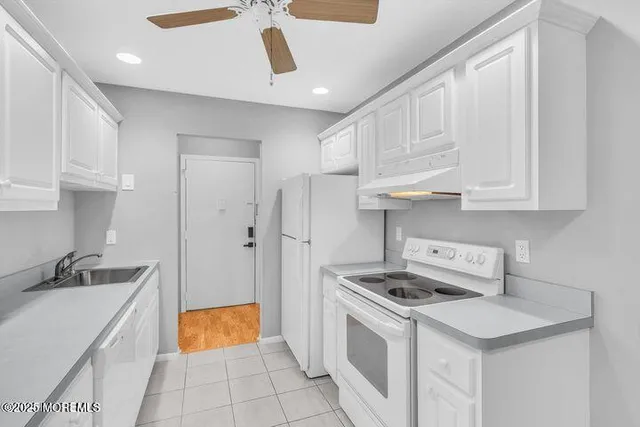 a kitchen with stainless steel appliances white cabinets and a sink