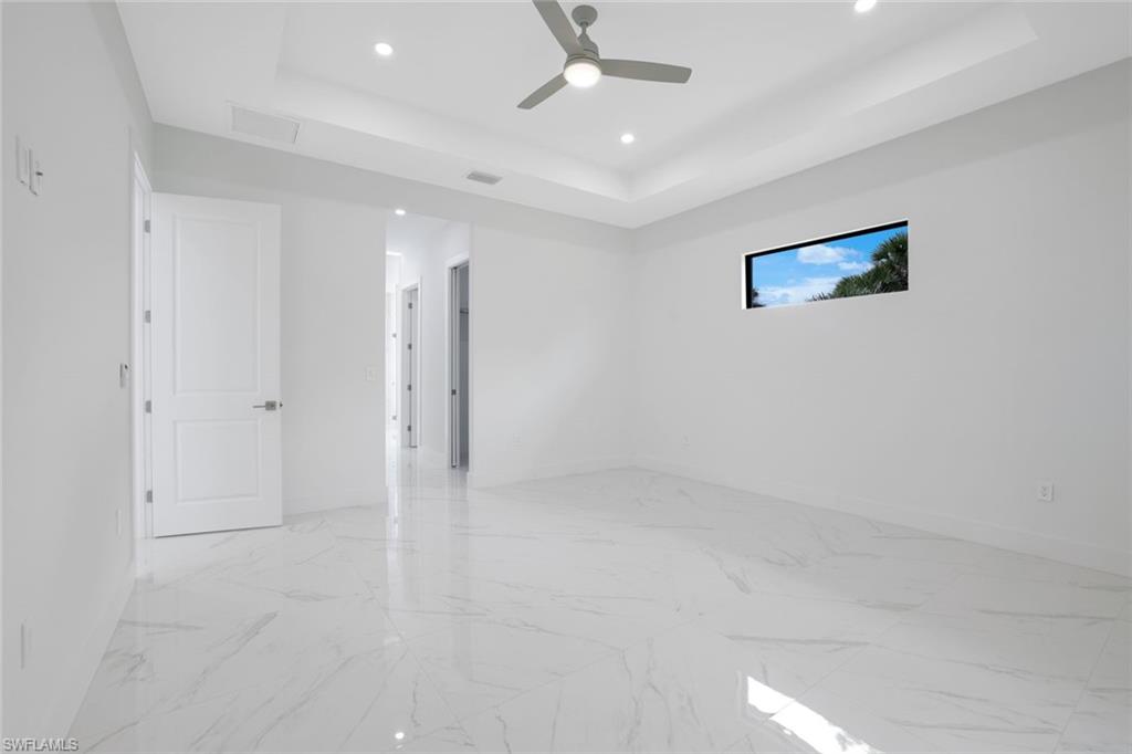 1068 16th Street Northeast Naples, FL 34120 - Photo 11 of 35 en empty room with white walls and ceiling fan