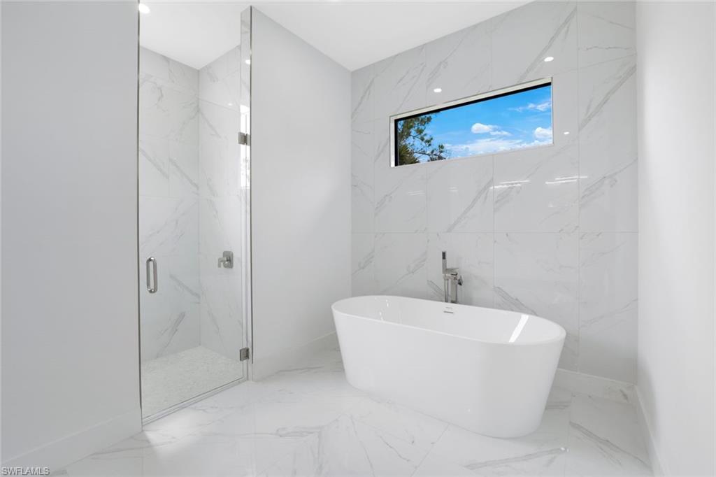 1068 16th Street Northeast Naples, FL 34120 - Photo 15 of 35 a bathroom with a white bath tub and shower