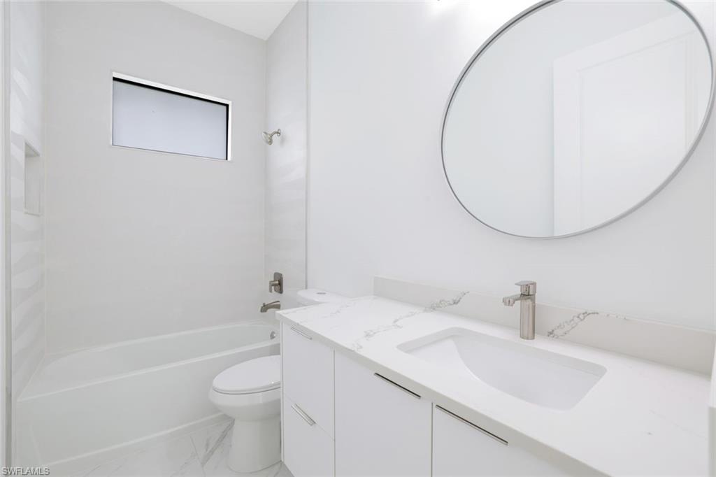 1068 16th Street Northeast Naples, FL 34120 - Photo 20 of 35 a bathroom with a sink a toilet and a mirror