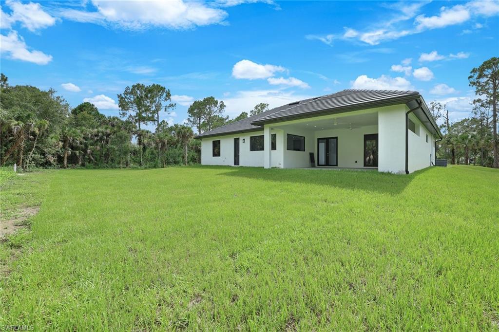 1068 16th Street Northeast Naples, FL 34120 - Photo 29 of 35 a front view of a house with yard and green space