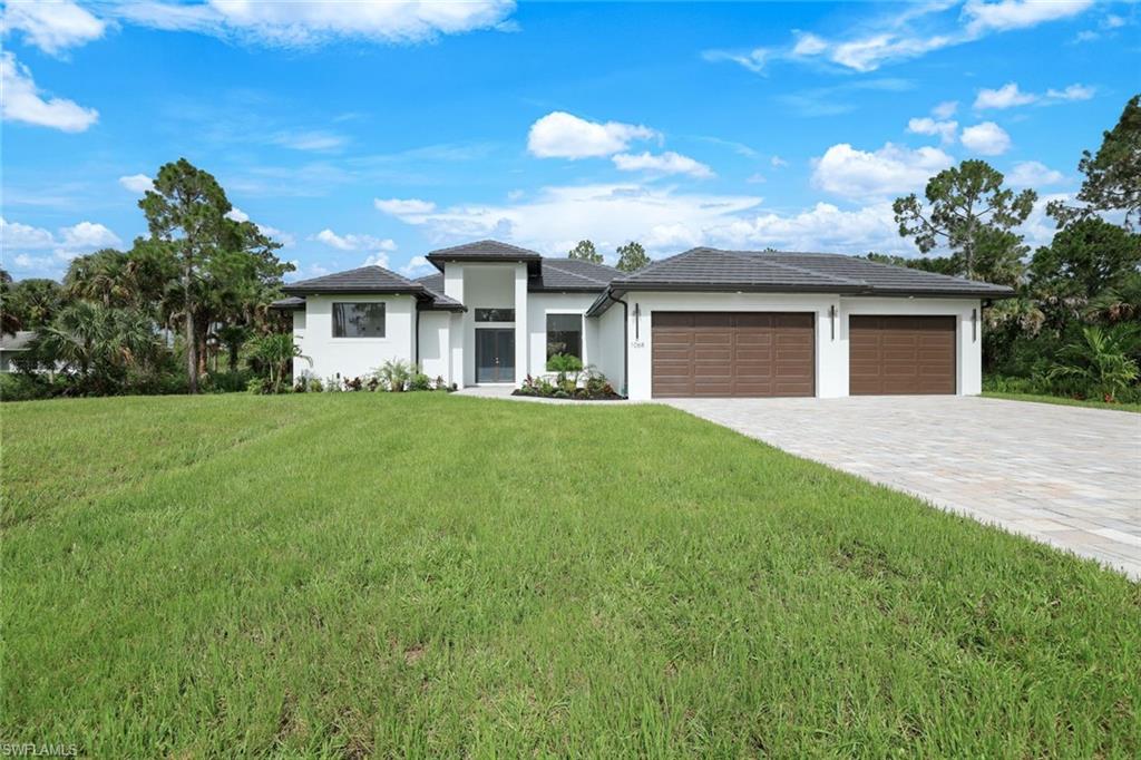 1068 16th Street Northeast Naples, FL 34120 - Photo 31 of 35 a front view of a house with a garden and yard