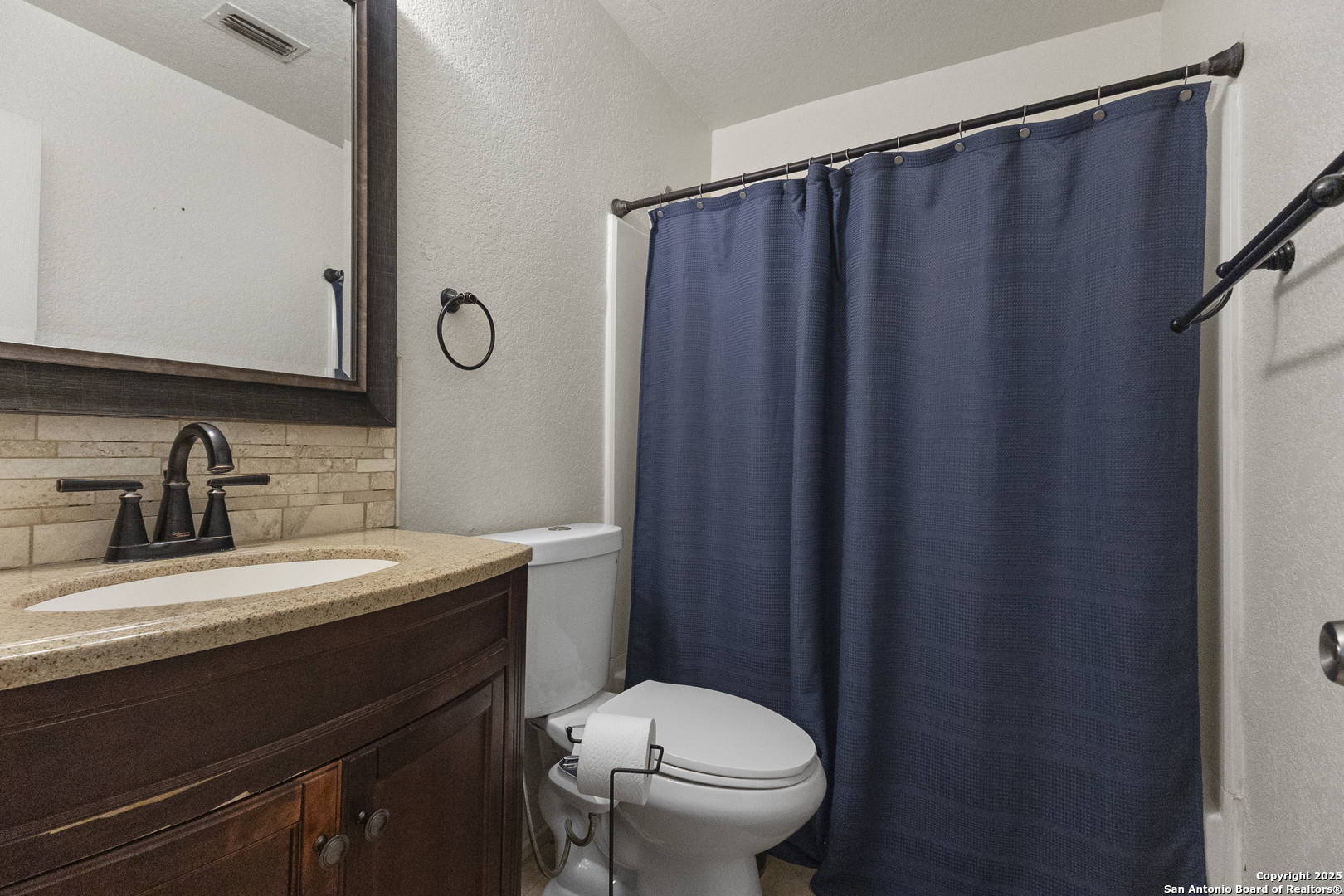707 Ridingate Farm San Antonio, TX 78228 - Photo 19 of 30 a bathroom with a sink a toilet a mirror and shower curtain