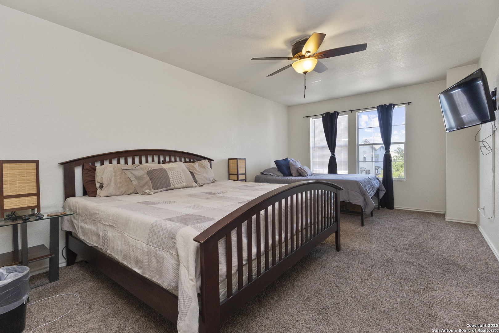 707 Ridingate Farm San Antonio, TX 78228 - Photo 20 of 30 a bedroom with a bed and a chandelier
