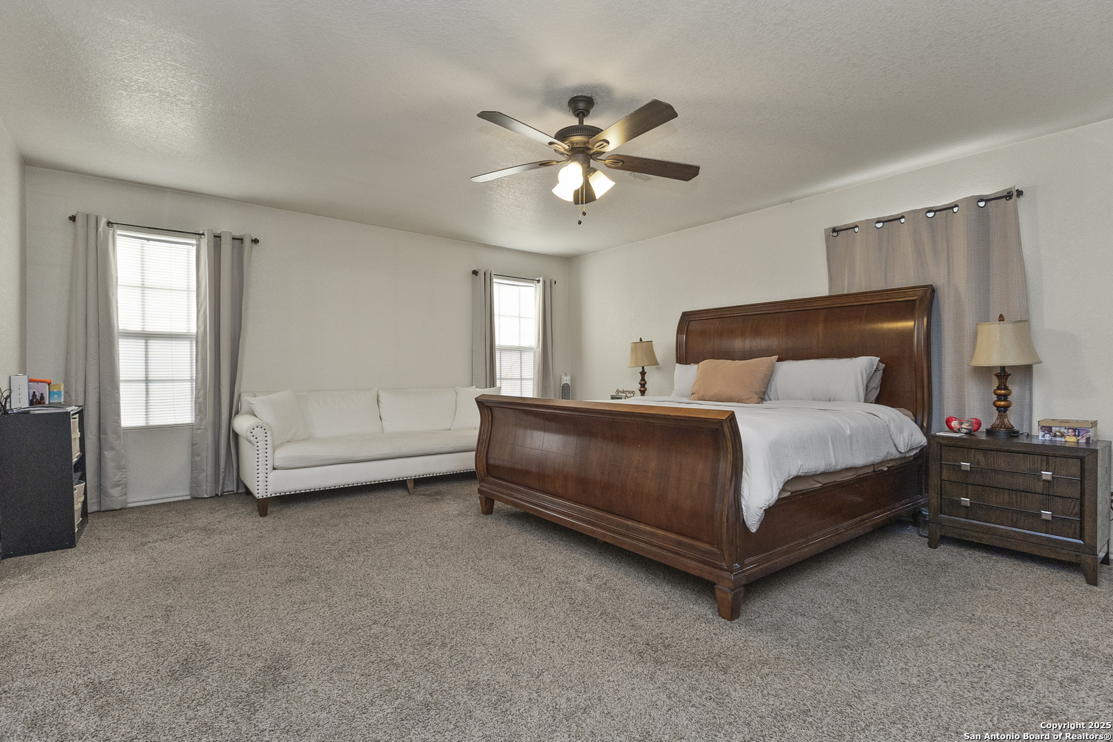 707 Ridingate Farm San Antonio, TX 78228 - Photo 22 of 30 a bedroom with a bed and a chandelier