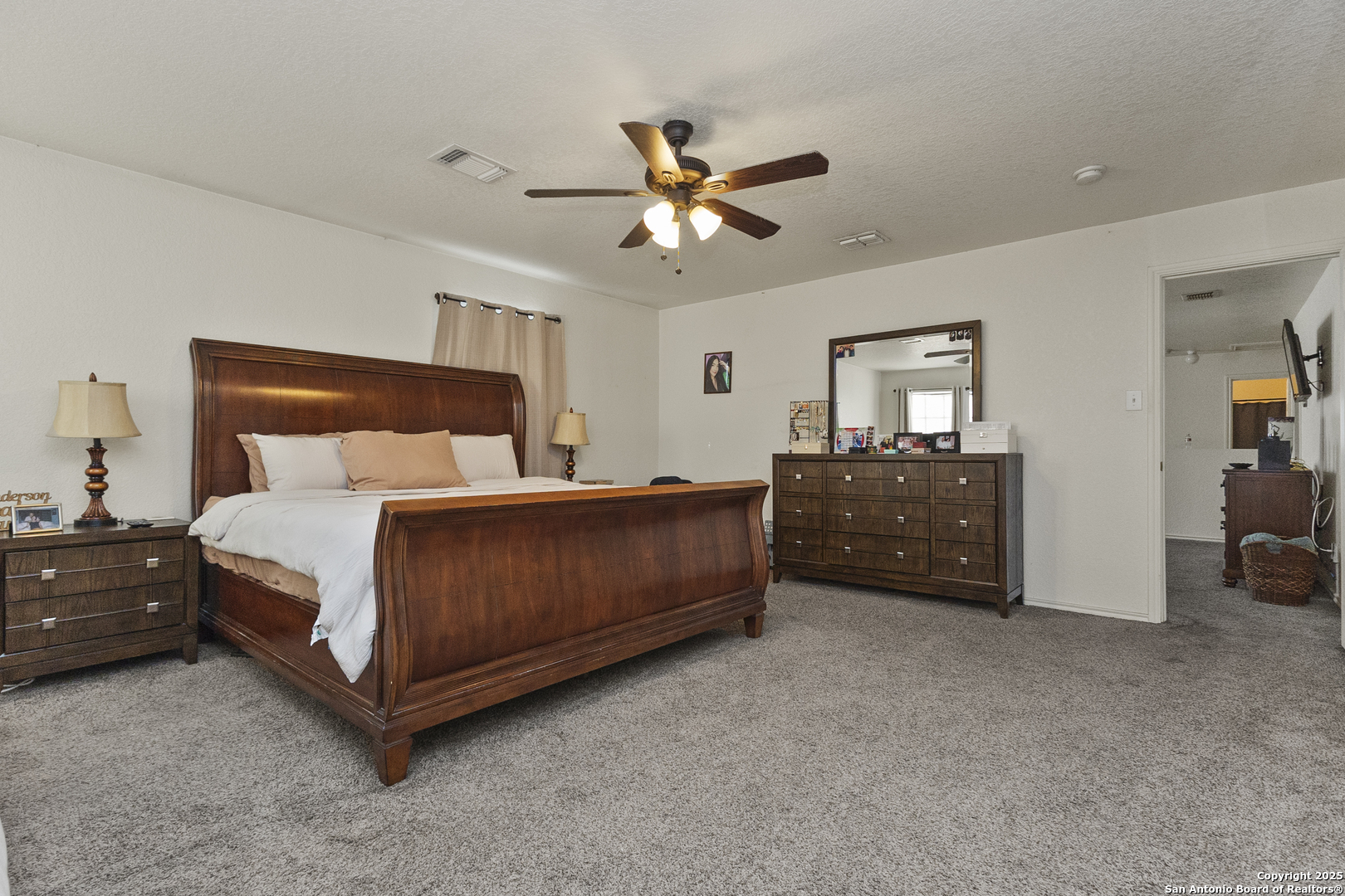 707 Ridingate Farm San Antonio, TX 78228 - Photo 23 of 30 a bedroom with a bed and a chandelier