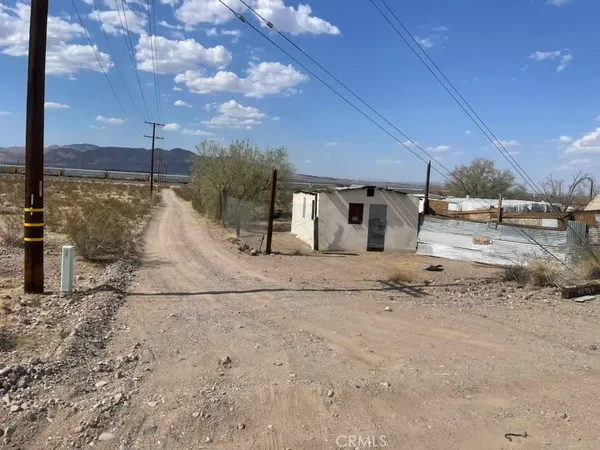 a view of a dry yard with wooden fence