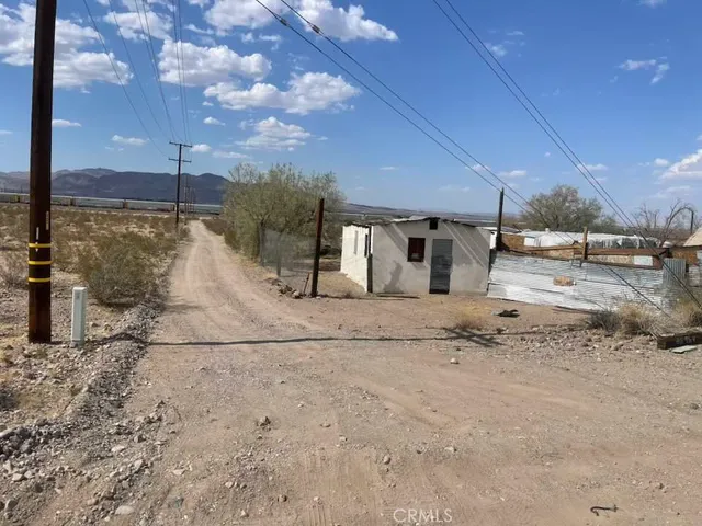 a view of a dry yard with wooden fence