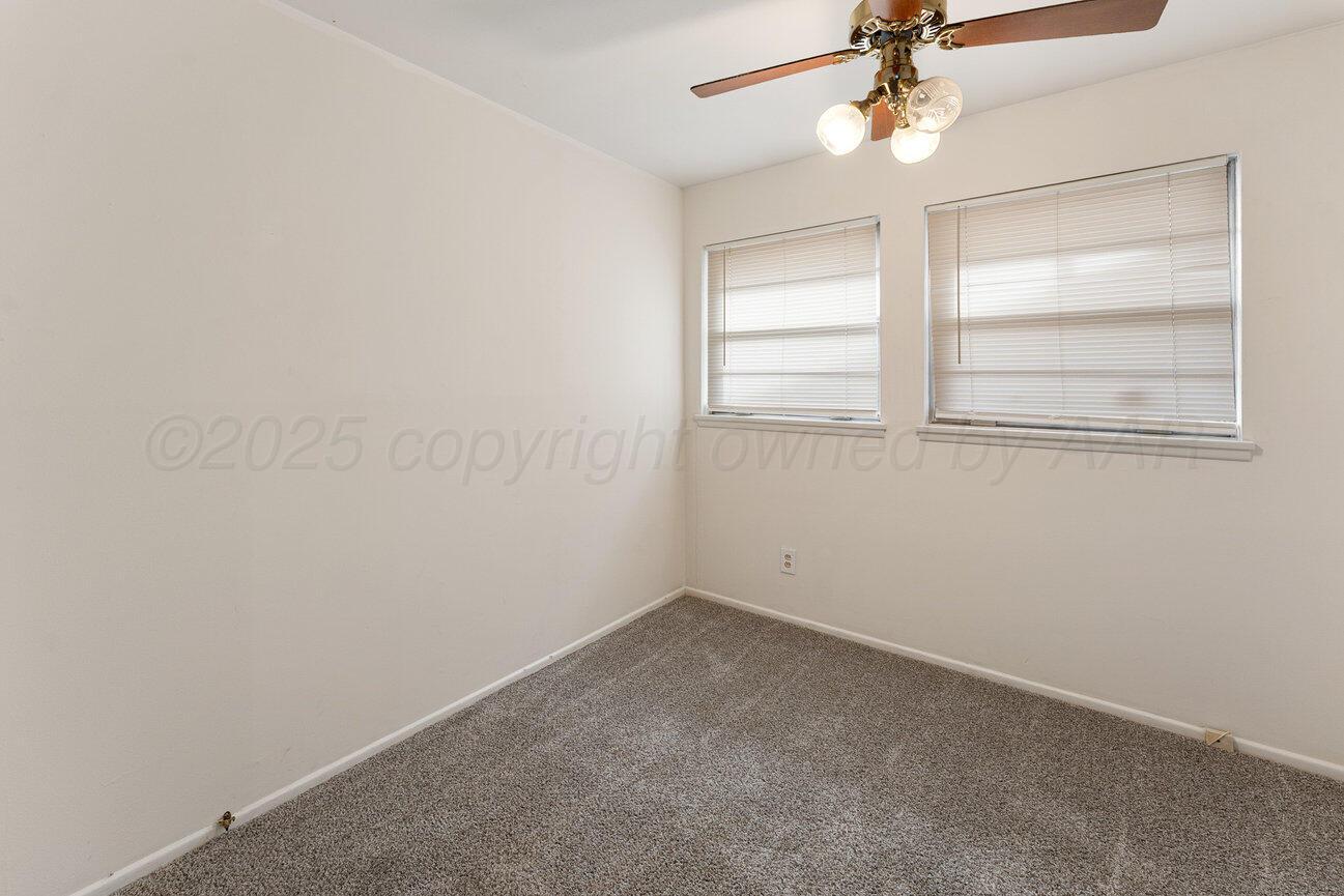 1133 Elmore Street Borger, TX 79007 - Photo 30 of 43 an empty room with a window and ceiling fan