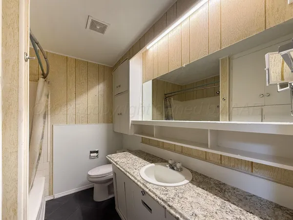 a bathroom with a granite countertop sink and a mirror