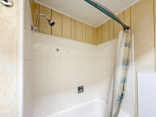 a bathroom with a bathtub and shower