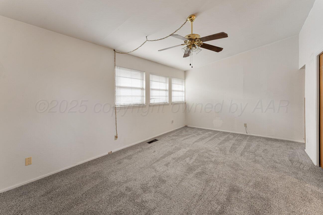 1133 Elmore Street Borger, TX 79007 - Photo 5 of 43 an empty room with windows and fan