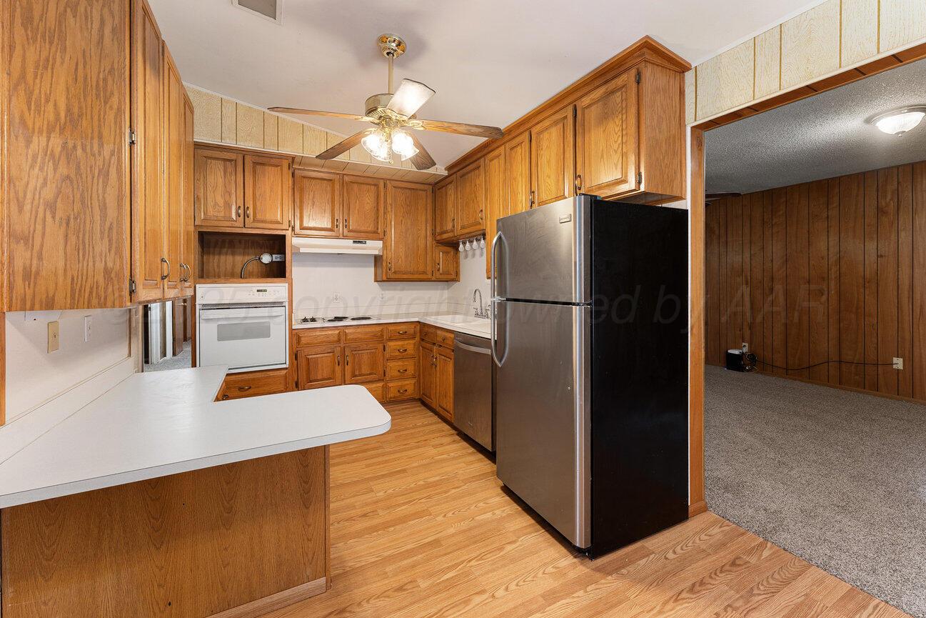 1133 Elmore Street Borger, TX 79007 - Photo 9 of 43 a kitchen with stainless steel appliances a refrigerator and a stove top oven