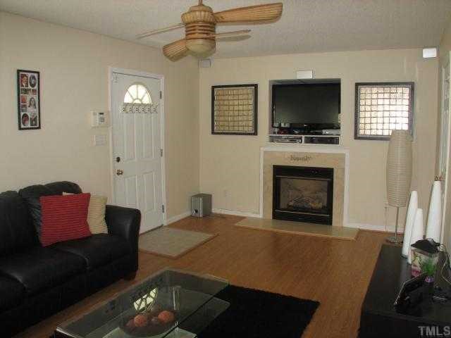 4833 Windbreak Lane Raleigh, NC 27616 - Photo 3 of 5 a living room with furniture a flat screen tv and a fireplace