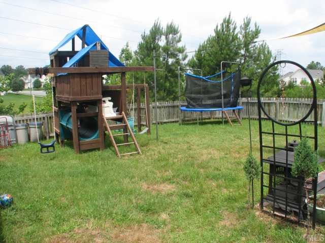 4833 Windbreak Lane Raleigh, NC 27616 - Photo 5 of 5 a view of a garden with a slide and a bench