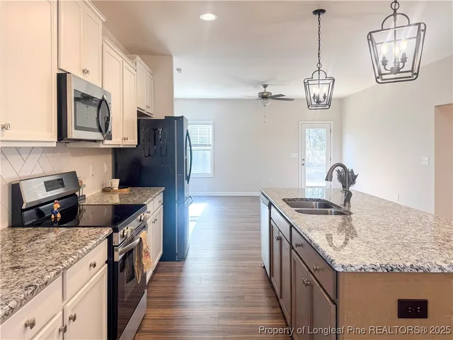 a view of an empty room with wooden floor fireplace and a window