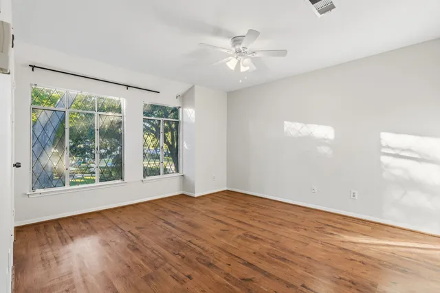 a view of an empty room with wooden floor