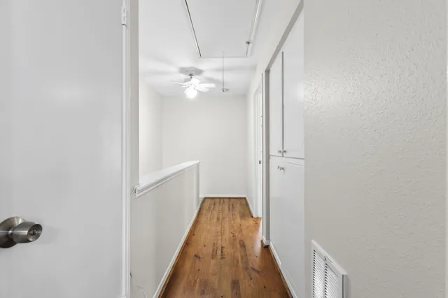 a view of a hallway with wooden floor